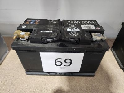 un gros plan d'un boîtier de batterie noir portant le numéro 69