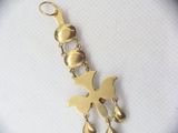 a gold charm with a bird on it on a white surface