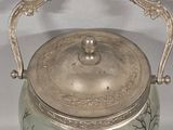 a silver teapot with a tree design on it