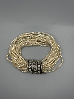un gros plan sur un bracelet orné de perles et muni d'un fermoir