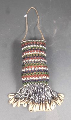 un sac auquel sont suspendus des coquillages, posé sur une table