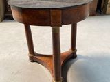 une image représentant une table ronde avec un plateau en marbre et des pieds en bois
