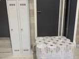 plusieurs rouleaux de papier toilette posés sur une palette près d'une porte