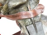 a statue of a man holding a knife on a rock