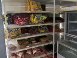 un réfrigérateur et un congélateur dans un magasin rempli de snacks