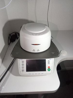 un micro-ondes posé sur une table sur laquelle se trouve une horloge