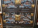 une commode noire et dorée dans un salon