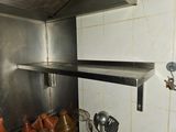 a metal shelf that has pots and utensils on it