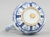 a blue and white vase with a gold decoration on it