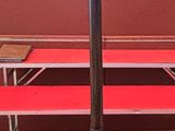 un porte-manteau et trois bancs rouges dans une pièce