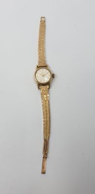 l'image d'une montre en or sur une surface blanche