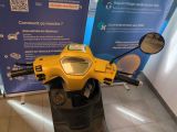 a yellow motorcycle parked in front of a blue sign