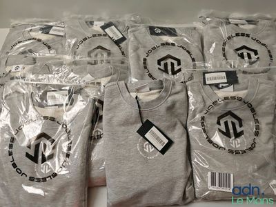 Plusieurs t-shirts sont emballés dans des sacs en plastique sur une table