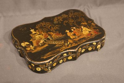 an image of a black and gold box with flowers on it