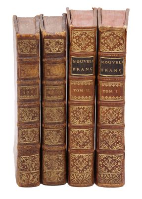 quatre vieux livres sont alignés sur une surface blanche
