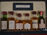 six bottles of alcohol in a case on a table