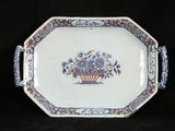 a blue and white plate with a basket of flowers on it