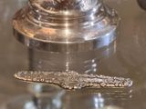 une cuillère en argent posée sur une table en verre