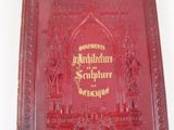 un livre rouge avec des inscriptions dorées
