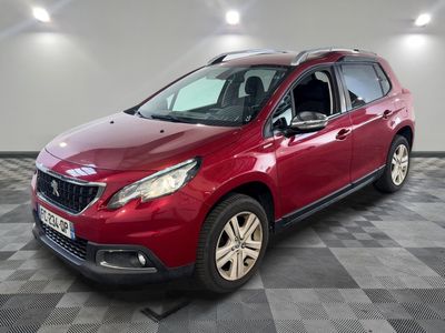 une voiture rouge garée sur le sol en damier d'un garage