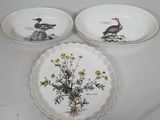 deux assiettes ornées d'oiseaux et de fleurs, posées sur une table