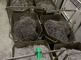 de nombreuses poubelles remplies de papier déchiqueté et une bouteille verte