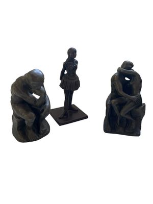 trois figurines représentant un homme et une femme assis sur un banc
