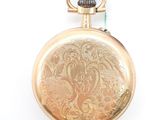 an old gold pocket watch with a chain hanging from it ' s side