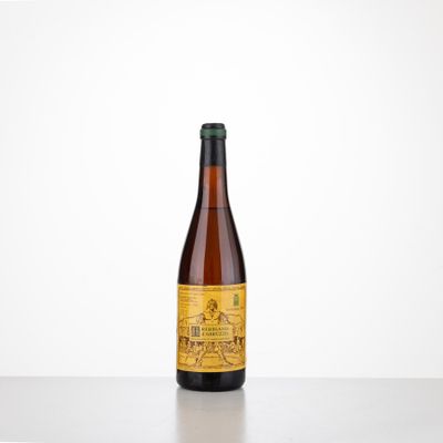 a bottle of beer sitting on top of a table next to a white wall