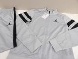 a white and black jacket and pants sitting on top of a table