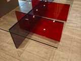 a glass table with a red glass top on a tiled floor
