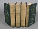 trois livres sont empilés sur une table