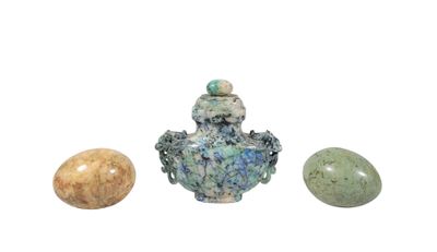 three stones and a vase sitting next to each other