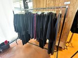 a lot of clothes hanging on a rack in a room