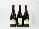 trois bouteilles de vin posées sur une table blanche