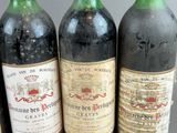 four bottles of wine are lined up on a table
