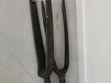 two tongs hanging on the wall next to each other