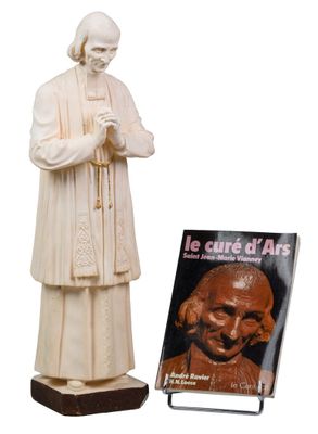 statue d'un homme tenant un livre, à côté d'une statue d'un moine
