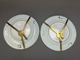 two plates with gold trims on them with a clock on them