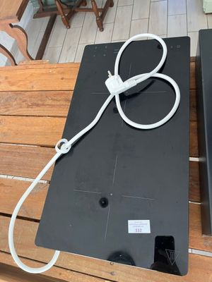 two laptops sitting on a wooden table with wires attached to them