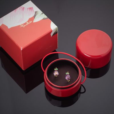 une boîte rouge et une paire de boucles d'oreilles posées sur une table