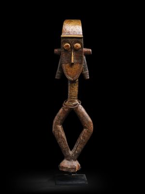 une sculpture en bois représentant un homme coiffé d'un chapeau