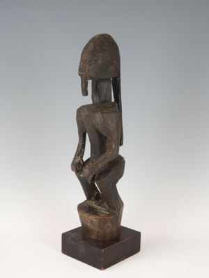 une image représentant une statue en bois d'un homme portant un casque sur la tête