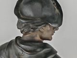 a statue of a man wearing a hat and a coat