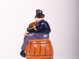 a figurine of a man sitting on top of a barrel