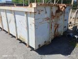 a rusted dumpster with a dog sticking out of it