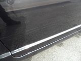 a close up of a car door handle with a person walking by