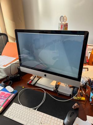 a computer monitor sitting on a desk with a keyboard and mouse