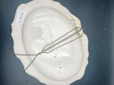 a white plate with a wire in it on a table
