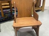une chaise en bois qui se trouve dans une pièce